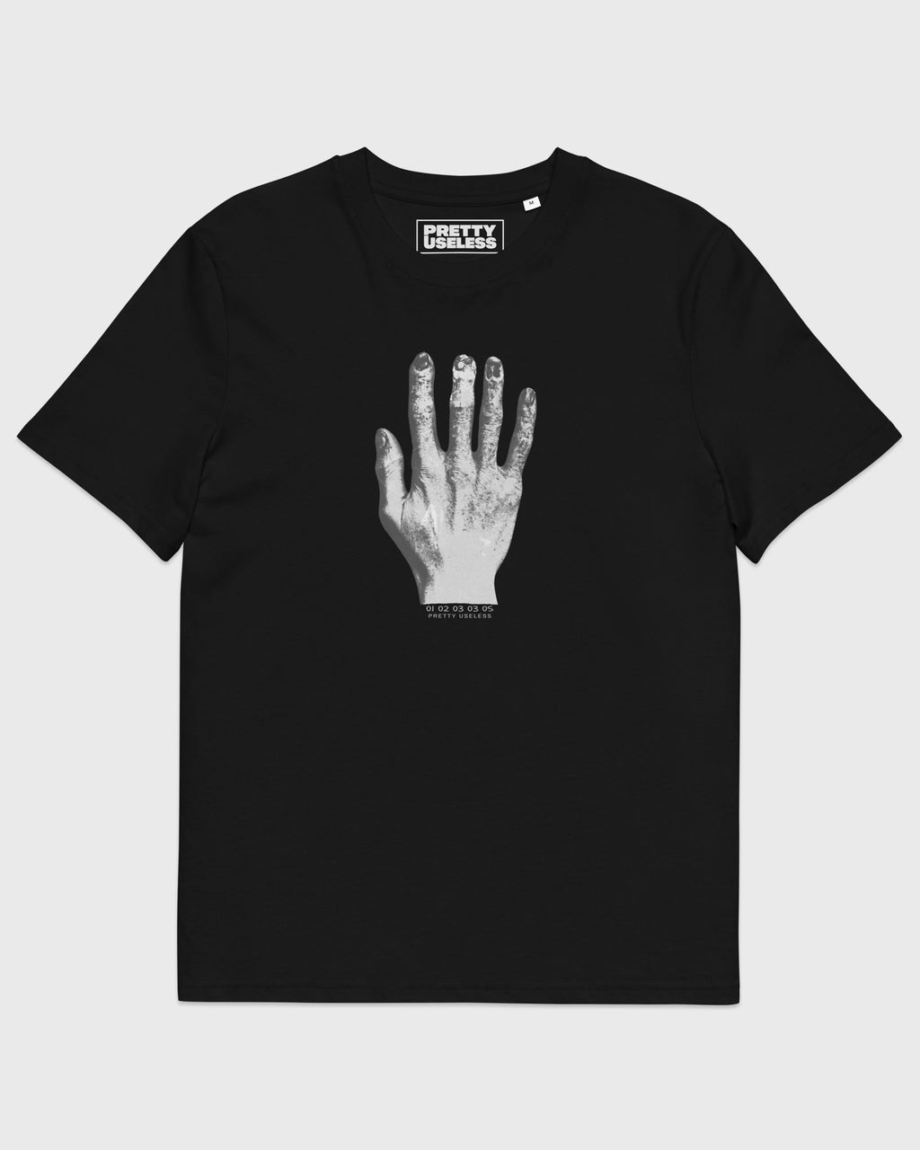 Frontansicht eines schwarzen PRETTY USELESS T-Shirts mit weiß-grauem Handmotiv auf der Brust.