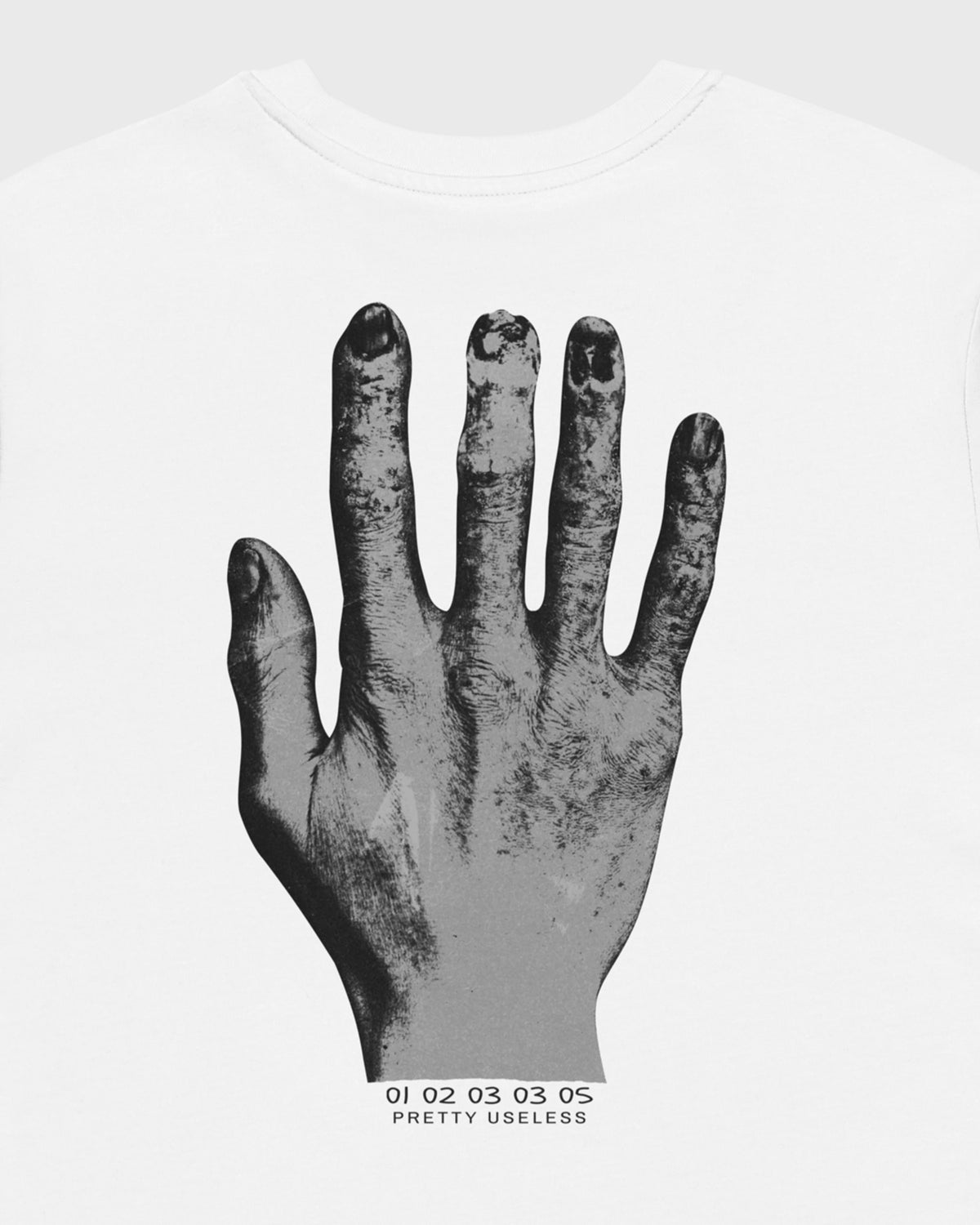 Detailansicht des großen schwarzen Handmotivs auf der Rückseite eines weißen PRETTY USELESS T-Shirts.