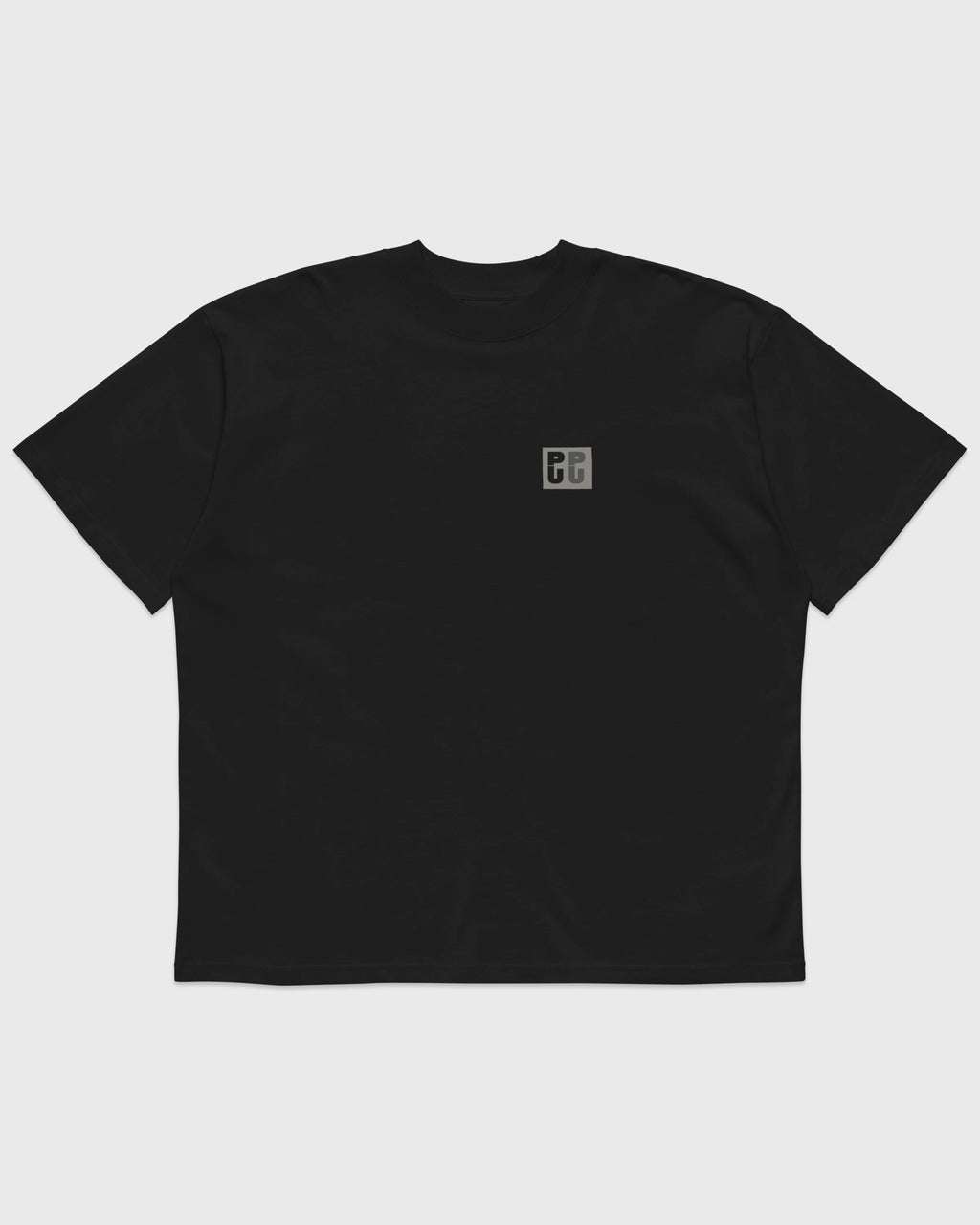 Frontansicht eines schwarzen PRETTY USELESS Oversized T-Shirts mit kleinem grauen PU Logo auf der Brust.