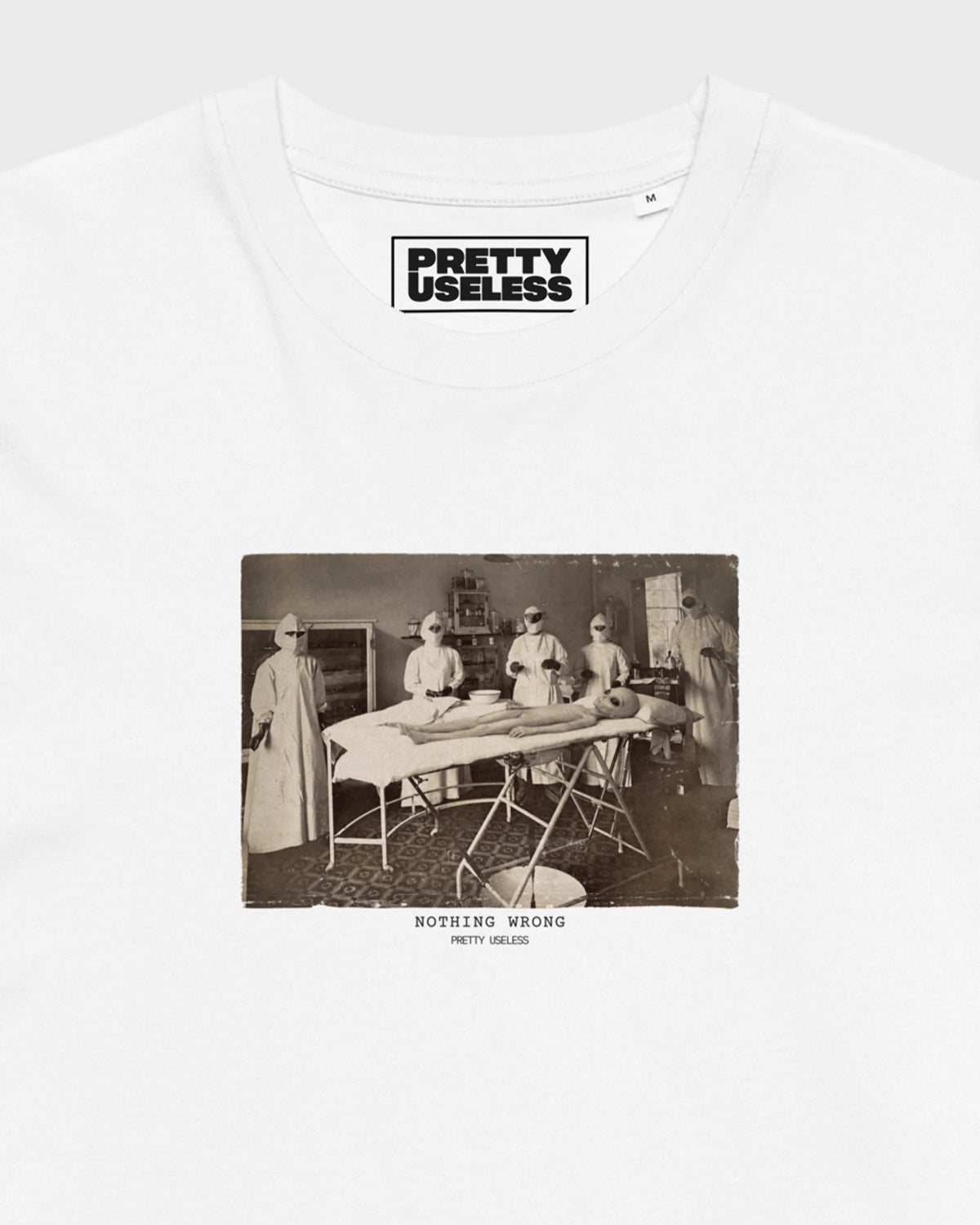 Detailansicht des NOTHING WRONG Operationsmotivs auf einem weißen PRETTY USELESS T-Shirt.