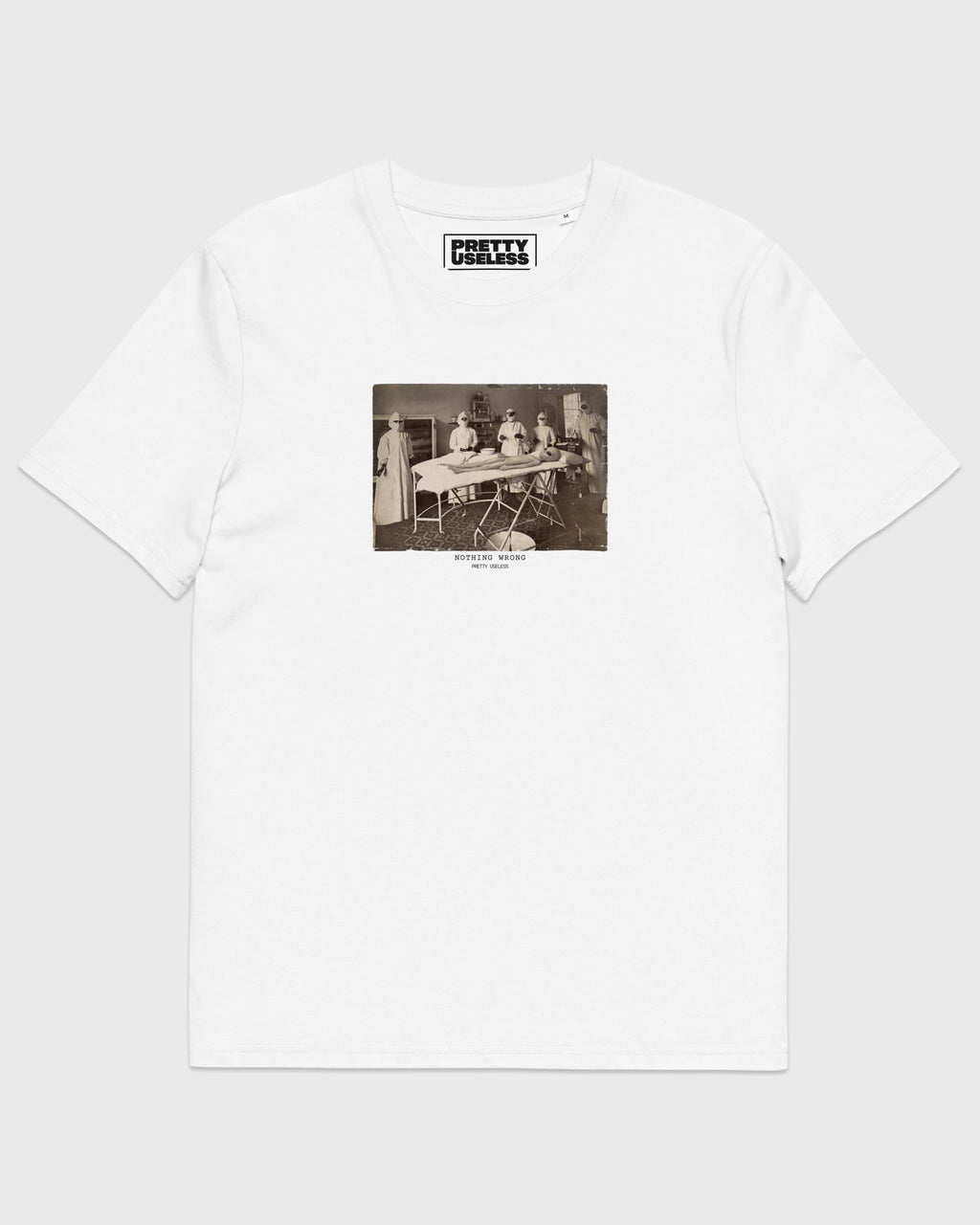 Frontansicht eines weißen PRETTY USELESS T-Shirts mit NOTHING WRONG Operationsmotiv auf der Brust.