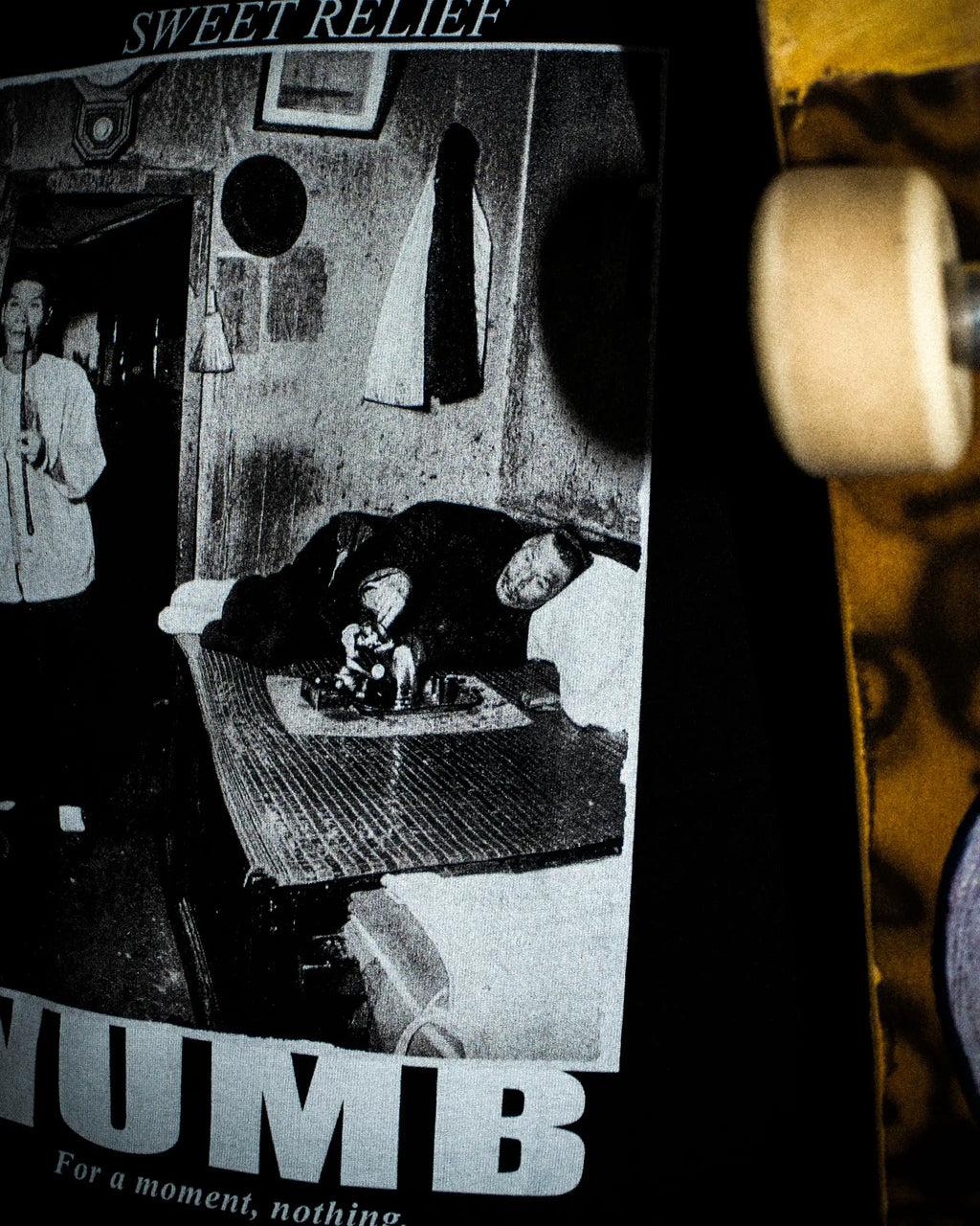 Detailaufnahme eines schwarzen PRETTY USELESS T-Shirts mit NUMB Print und sichtbarer Druckstruktur.