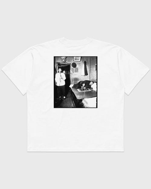Rückansicht eines weißen PRETTY USELESS Oversized T-Shirts mit großem schwarz-weißen Fotomotiv auf dem Rücken.