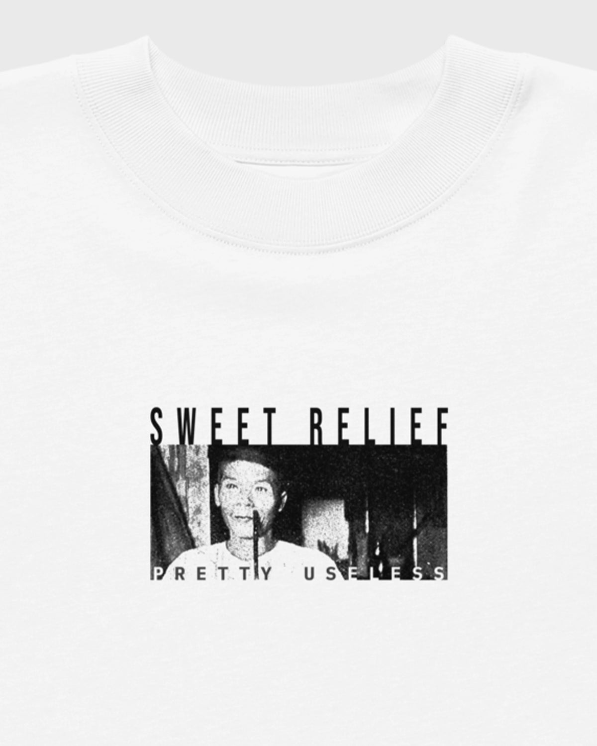 Detailansicht des kleinen SWEET RELIEF Fotoprints auf der Brust eines weißen PRETTY USELESS Oversized T-Shirts.