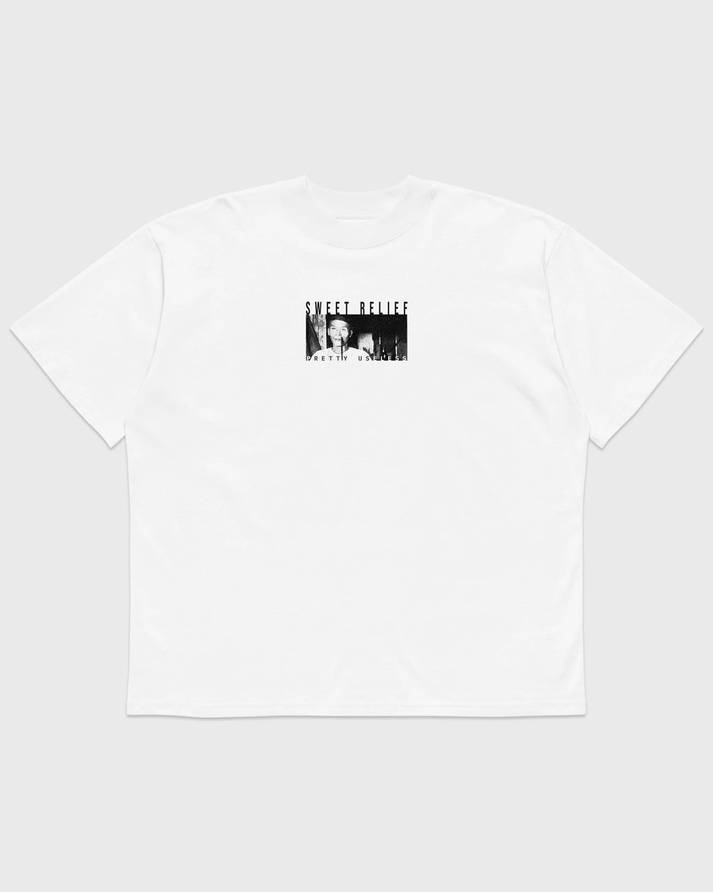 Frontansicht eines weißen PRETTY USELESS Oversized T-Shirts mit kleinem SWEET RELIEF Fotoprint auf der Brust.